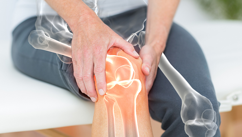 patient holding her knee in pain from osteoarthritis