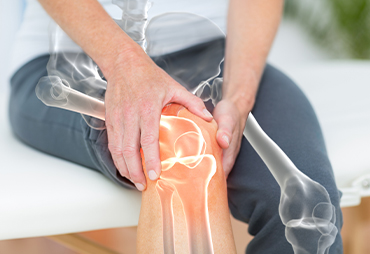 patient holding her knee in pain from osteoarthritis