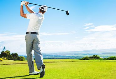 golfer swinging club at golf ball