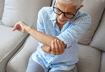 patient holding elbow in pain due to elbow bursitis